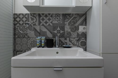 米兰Espinasse Apartment的白色浴室内的白色水槽,铺有瓷砖