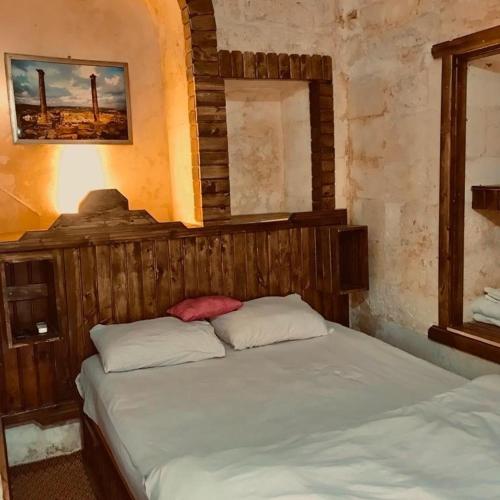 尚勒乌尔法Alkan konuk evi的一间卧室配有一张带木制床头板的床