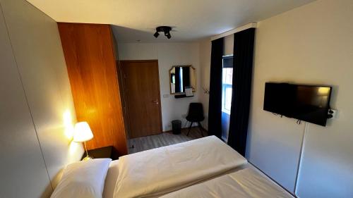 BolungarvíkWestfjords - Rooms的一间卧室配有一张床和一台平面电视