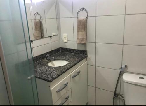 莫索罗Apartamento em Mossoró的一间带水槽、镜子和卫生间的浴室