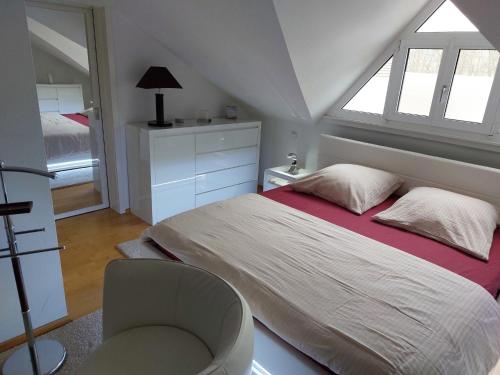 AltenkunstadtFerienwohnung DG的卧室配有床、椅子和窗户。