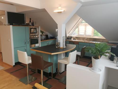 AltenkunstadtFerienwohnung DG的厨房配有蓝色橱柜和桌椅