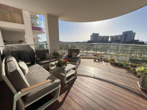 特拉维夫Luxury sea view apartment的大楼内的阳台配有沙发和椅子