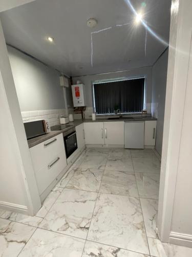 Lumiere luxury apartment的一间铺有大理石地板并配有白色橱柜的厨房