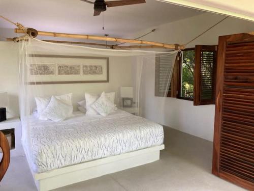 TlachicónVilla Lavanda Puerto Escondido Beachfront的卧室配有白色的床和窗户。