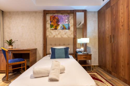 阿尔及尔Hotel Hammamet的一间卧室配有带毛巾的床