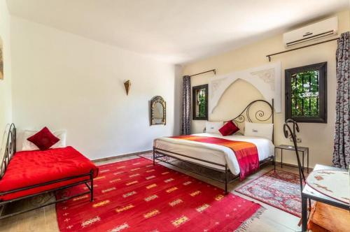 Aïn Cheggag卡萨尔德菲斯酒店的一间卧室配有一张床和红色地毯