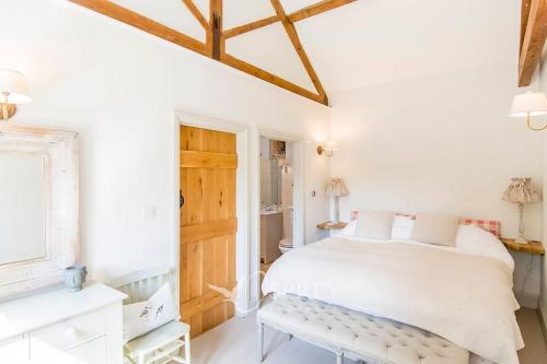 昂德尔Olive的白色卧室设有床铺和木制天花板