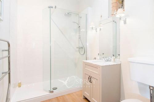 昂德尔Olive的带淋浴和盥洗盆的白色浴室