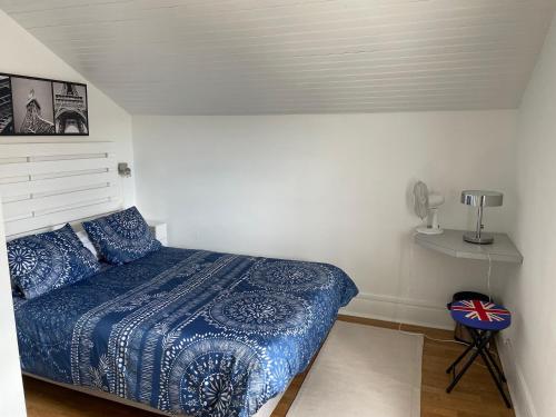 圣艾蒂安À la maison的一间卧室配有一张带蓝色棉被的床
