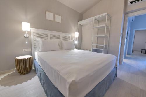 基拉奇尼Cocoon Elegant Living的卧室配有白色大床和书架