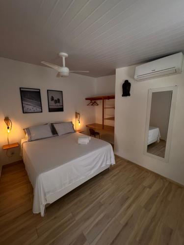 卡姆布库Bada Hostel & Kite School的卧室配有白色的床和镜子