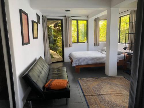 JaibalitoRustic Charm Cliffside Retreat的一间卧室配有一张床、一张沙发和窗户。