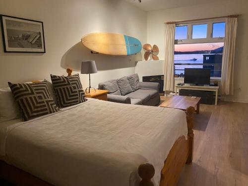 托菲诺弗雷德狄博思岛村酒店的卧室配有一张床,墙上设有冲浪板
