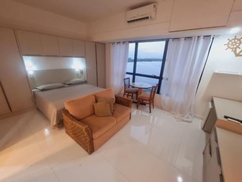 马瑙斯Tropical Executive Vista Ponta Negra的一间卧室配有一张床、一把椅子和一张桌子