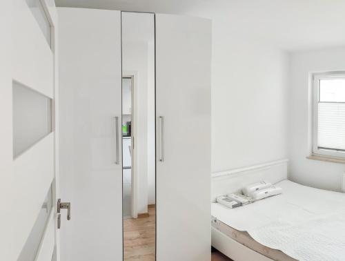 克拉科夫Apartment Szwed-Sniadowskiej Residence的卧室设有白色的墙壁、一张床和镜子