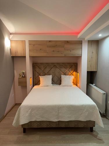 巴尼亚卢卡Amsterdam的一间卧室配有一张大床和木制床头板