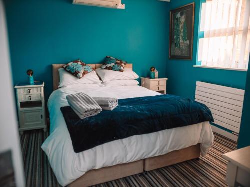 考斯Seafarer's View - 6 bedroom townhouse in Cowes, parking & seaviews.的一间卧室配有一张蓝色墙壁的床