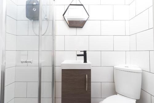 贝德沃思No5a, Studio Apartment, Willowbrook House的白色瓷砖浴室设有卫生间和水槽