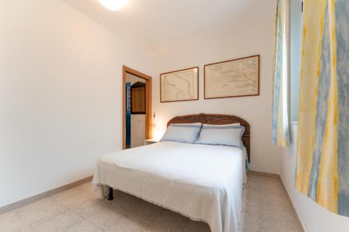 圣多米诺vacanze a tremiti的卧室配有白色的床和墙上的两张照片