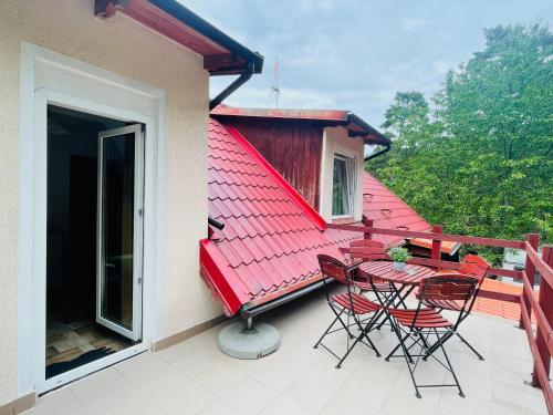 斯图托沃Róża Wiatrów的阳台设有红色屋顶,配有桌椅