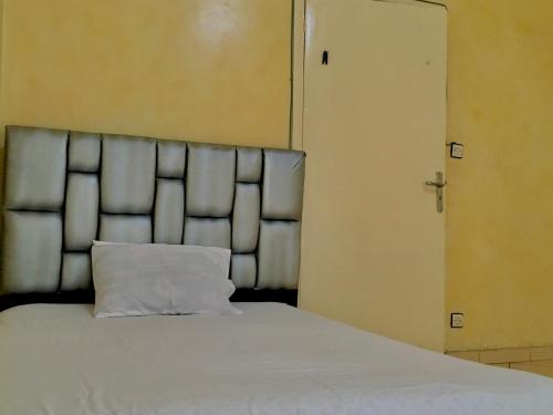 卡萨布兰卡BEA & DOZO的一张带白色枕头的床,位于门边
