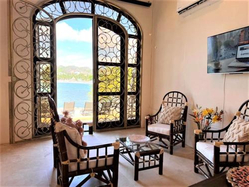 萨尤利塔Villa Amor的客厅设有拱形窗户和椅子