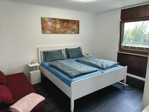 格洛韦URLAUB mit HUND -Ferienwohnung "AhriBella"-的一间卧室配有一张带蓝色床单的床和一扇窗户。