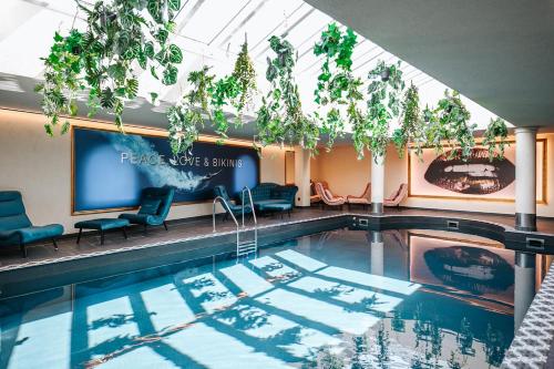 罗伊特Wellness Aparthotel "Lechlife" incl Infinity Pool - 400m zum Lift的一座带椅子和屏幕的游泳池