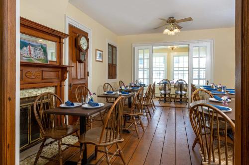 沃特伯里老驿站马车住宿加早餐旅馆的一间带桌椅和壁炉的用餐室