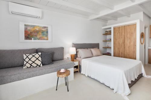 派莱卡斯Casa Sabbia 10m from the beach的白色卧室配有床和沙发