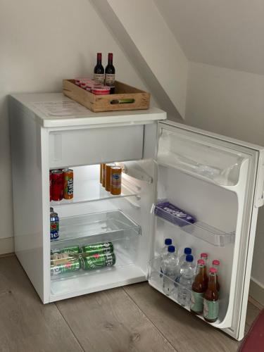 登堡Bed & Koffie, Op de Spinbaan的配有瓶装饮品的开放式冰箱