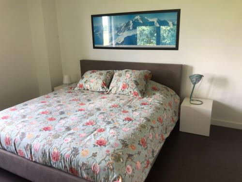 Zemstlandelijke villa met zwembad en gezellige openhaard的一间卧室配有一张带花卉棉被的床