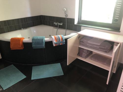 Zemstlandelijke villa met zwembad en gezellige openhaard的一间带毛巾和镜子的浴缸的浴室