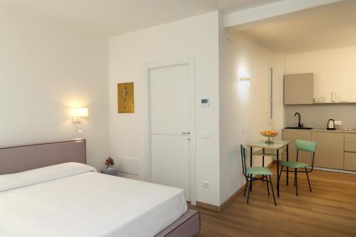 巴多利诺Ancora Suites的卧室配有一张床和一张桌子及椅子