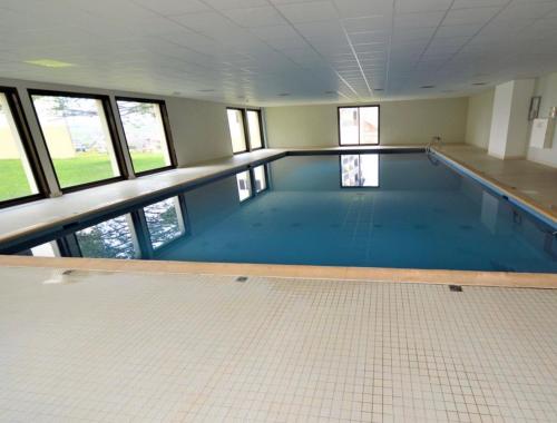 梅塔比耶Appartement cosy的大型游泳池设有瓷砖地板和窗户