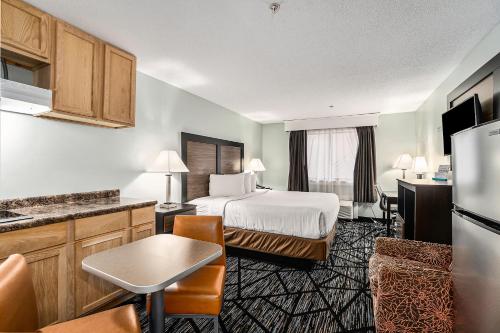 格兰德港Baymont by Wyndham Grand Haven的酒店客房带一张床和一个厨房