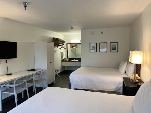 布兰森七阁楼旅馆的酒店客房设有两张床和一张书桌及电视