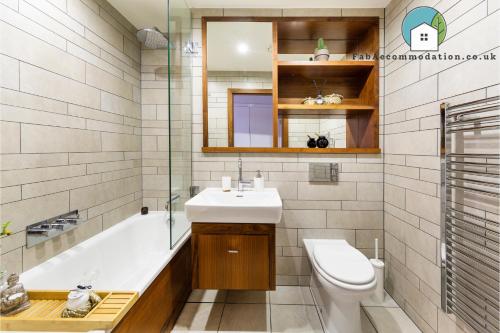 卡迪夫Amazing Flat-Parking available-By FabAccommodation的一间带水槽、浴缸和卫生间的浴室