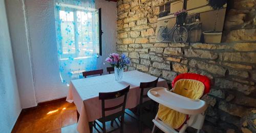 苏安塞斯HABITACIONES PRIVADAS - CASA RURAL - Baño compartido con los anfitriones的一间设有桌子和石墙的用餐室