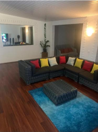 MahinaPacific Lodge的带沙发和蓝色地毯的客厅