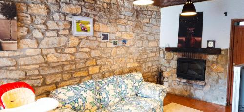 苏安塞斯HABITACIONES PRIVADAS - CASA RURAL - Baño compartido con los anfitriones的带沙发和石墙的客厅