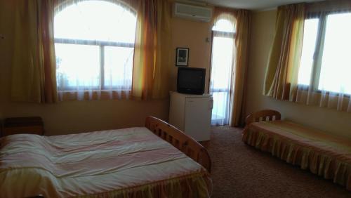 克兰内沃Stefan Family Hotel的客房设有两张床、一台电视和窗户。
