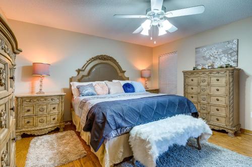 SemmesDog-Friendly Alabama Retreat with Patio and Fire Pit!的一间卧室配有一张床、两个梳妆台和吊扇