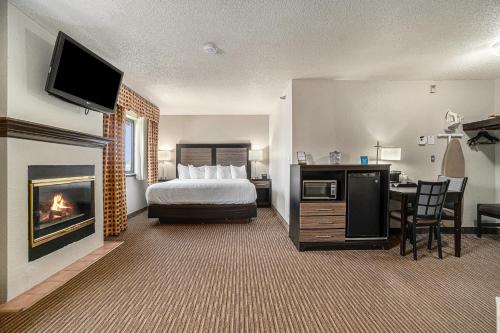特拉弗斯城特拉弗斯城戴斯套房酒店的酒店客房配有一张床和一个壁炉。
