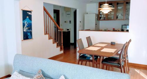 八王子市Guest house with host Takao SORA- Vacation STAY 13000的厨房以及带蓝色沙发和桌子的用餐室。