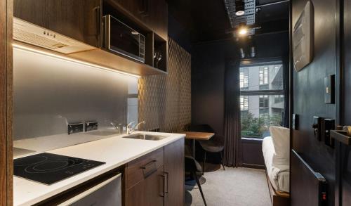 奥克兰Abstract Hotel & Residences的一间带水槽和炉灶的小厨房
