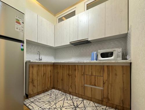 杜尚别Dushanbe City View Apartments的厨房配有白色橱柜和微波炉