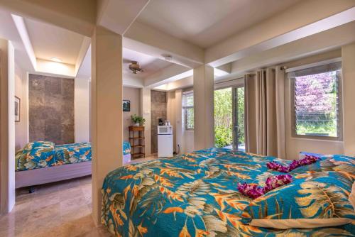 HueloGardenia Room on Tropical Lush Farm in Haiku, Maui的一间卧室配有一张大床和色彩缤纷的毯子