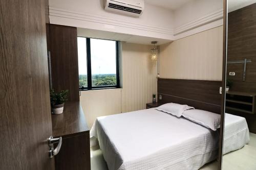 马瑙斯Tropical Executive 1006的卧室配有白色的床和窗户。